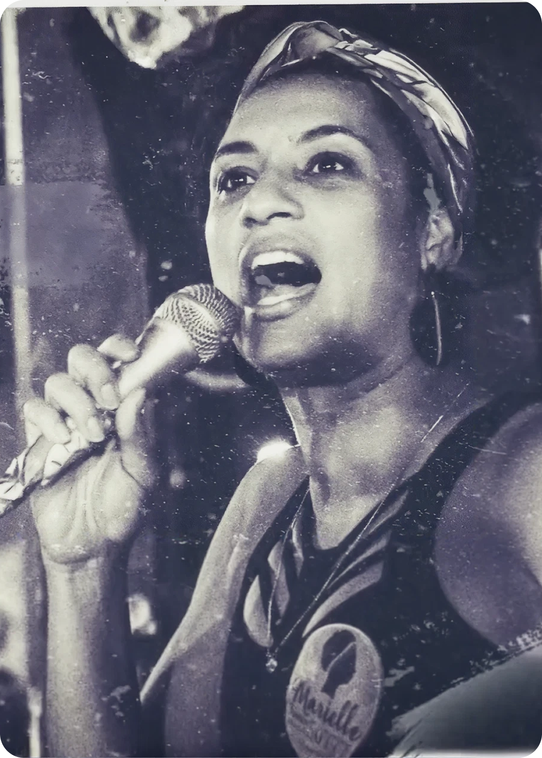 Black-and-white photo of a woman singing into a microphone, from Amnesty International Brazil's anniversary piece.